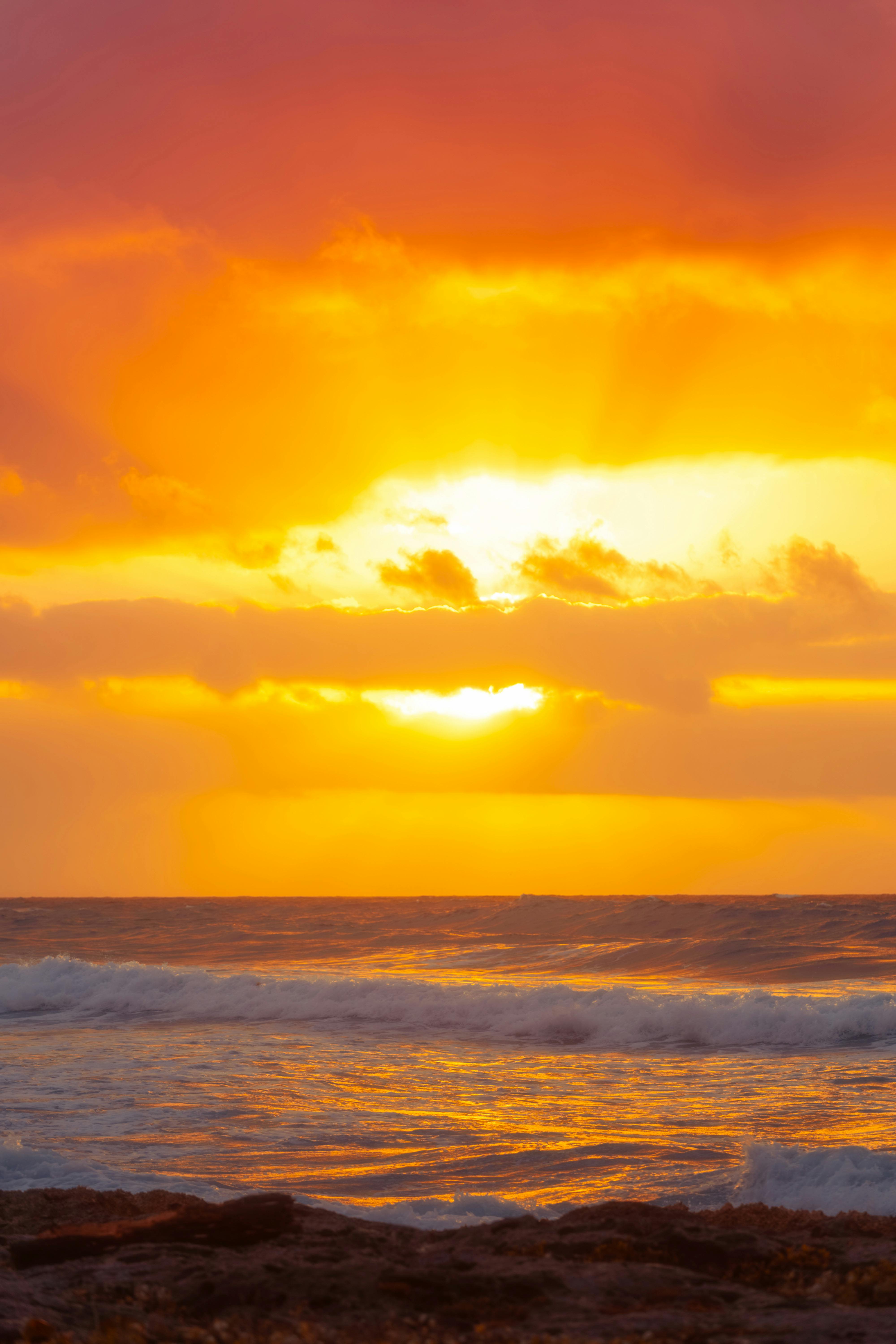 Breathtaking sunset over Akumal beach, vibrant colors illuminate the ocean waves. Ideal for travel and nature enthusiasts.