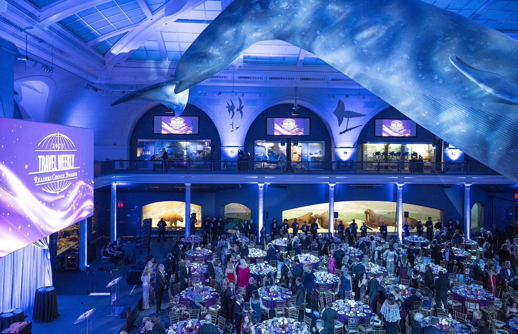person in blue shirt writing on white paper